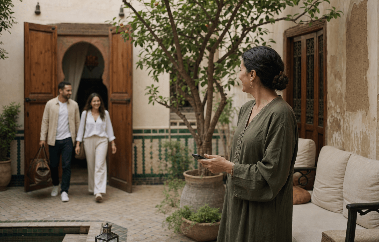 مضيف يرحّب بالضيوف في فناء تغمره الشمس